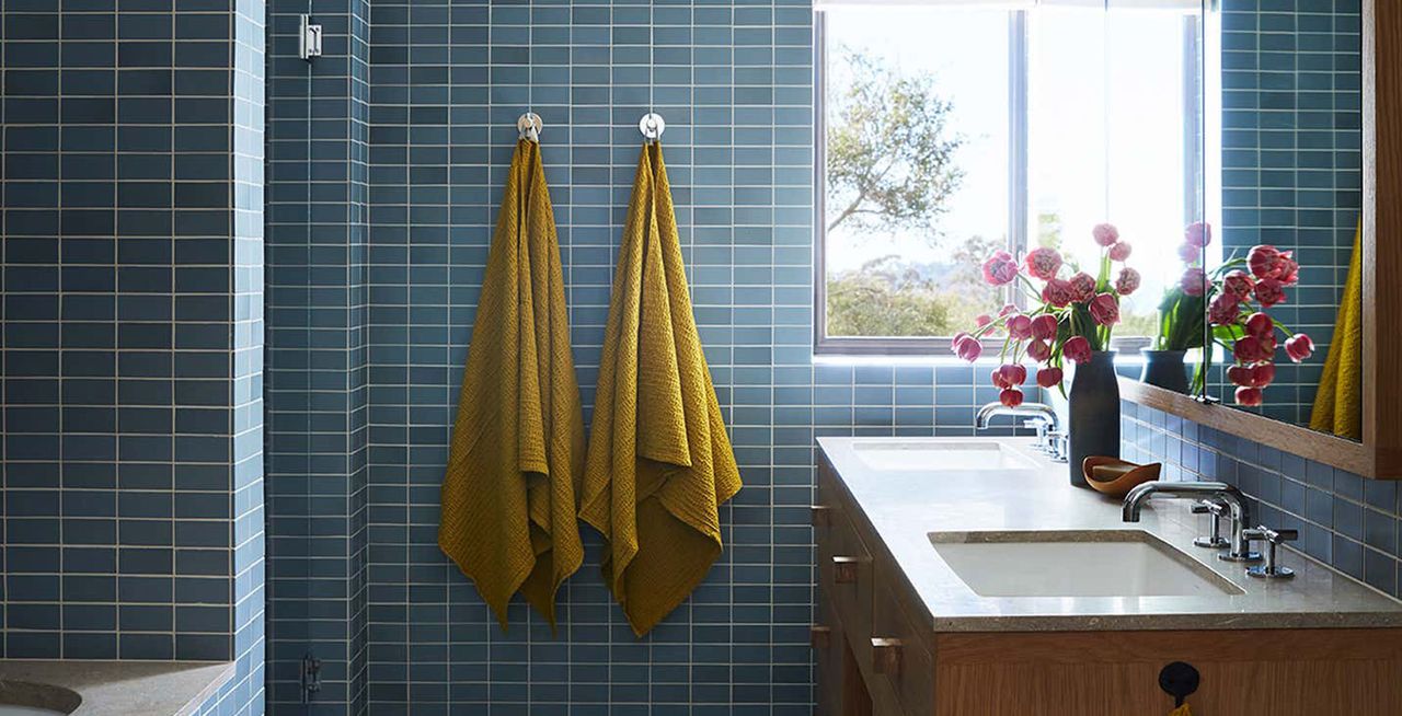 towels hanging up in a blue tiled bathroom