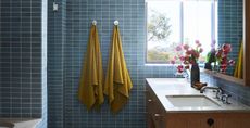 towels hanging up in a blue tiled bathroom