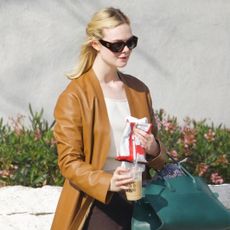 Elle Fanning wearing a tan leather coat