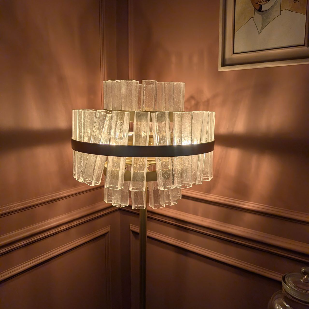 Glass shaded floor lamp in corner of terracotta coloured room