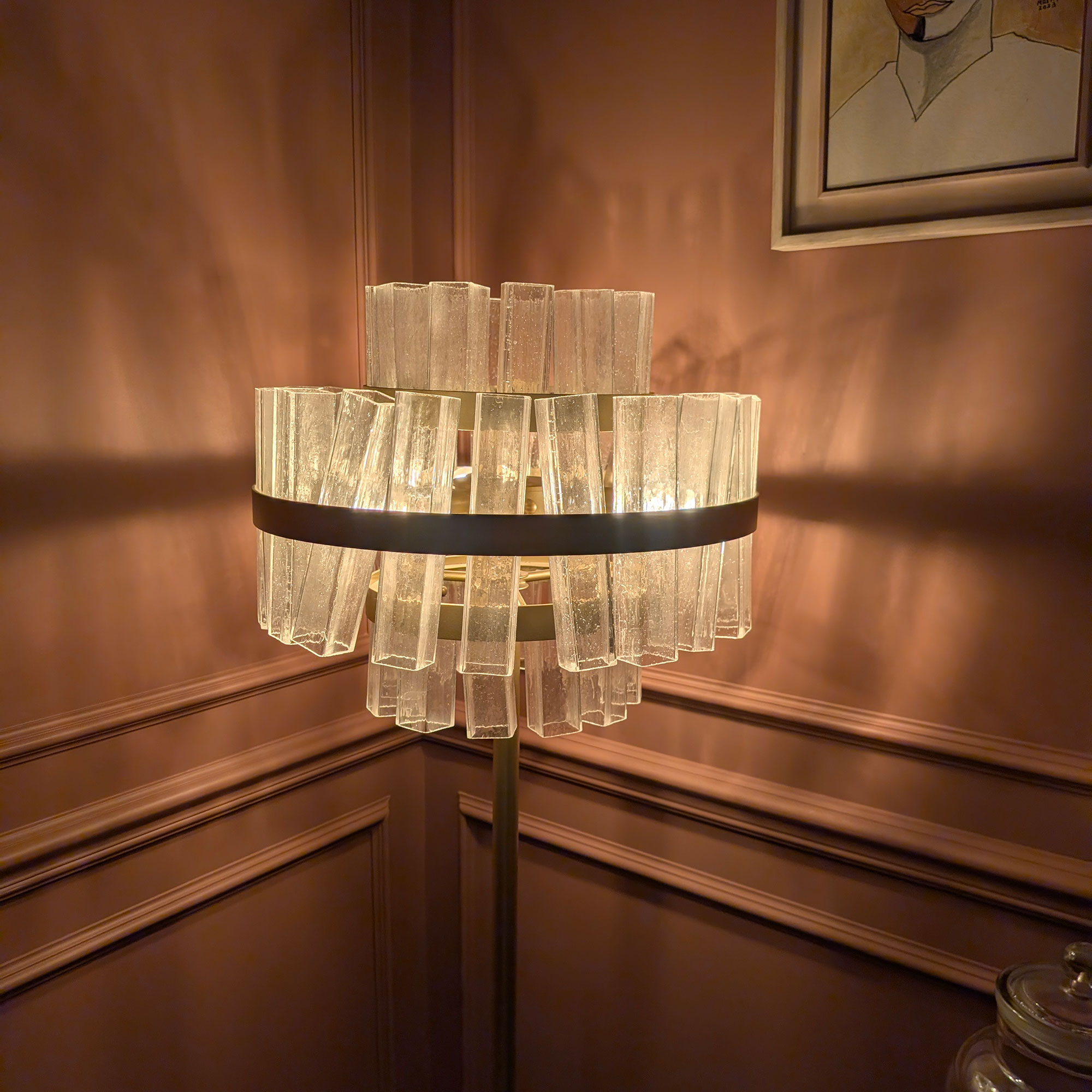Glass shaded floor lamp in corner of terracotta coloured room