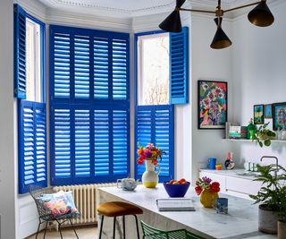 bright blue shutters on window in white kitchen