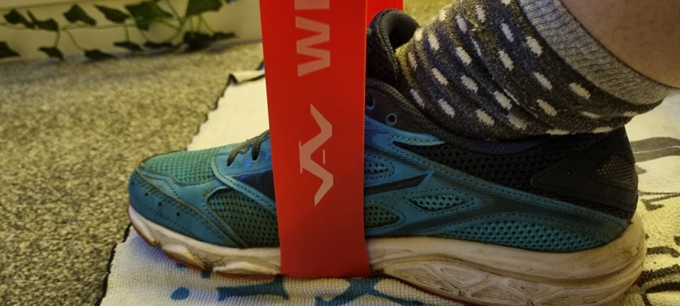 Whatafit resistance band being stretched over shoe