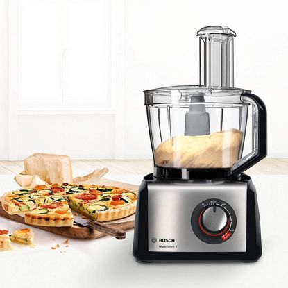 The Bosch MultiTalent 8 food processor with dough inside on a kitchen counter next to a quiche.