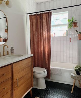 Small bathroom with brown shower curtain and plants