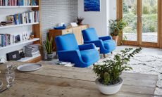 living room with white shelves on wall and blue sofaset