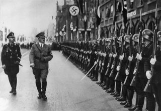 circa 1938:German dictator Adolf Hitler (1889 - 1945) and his chief of police Heinrich Himmler (1900 - 1945) inspecting the SS Guard.(Photo by Hulton Archive/Getty Images)
