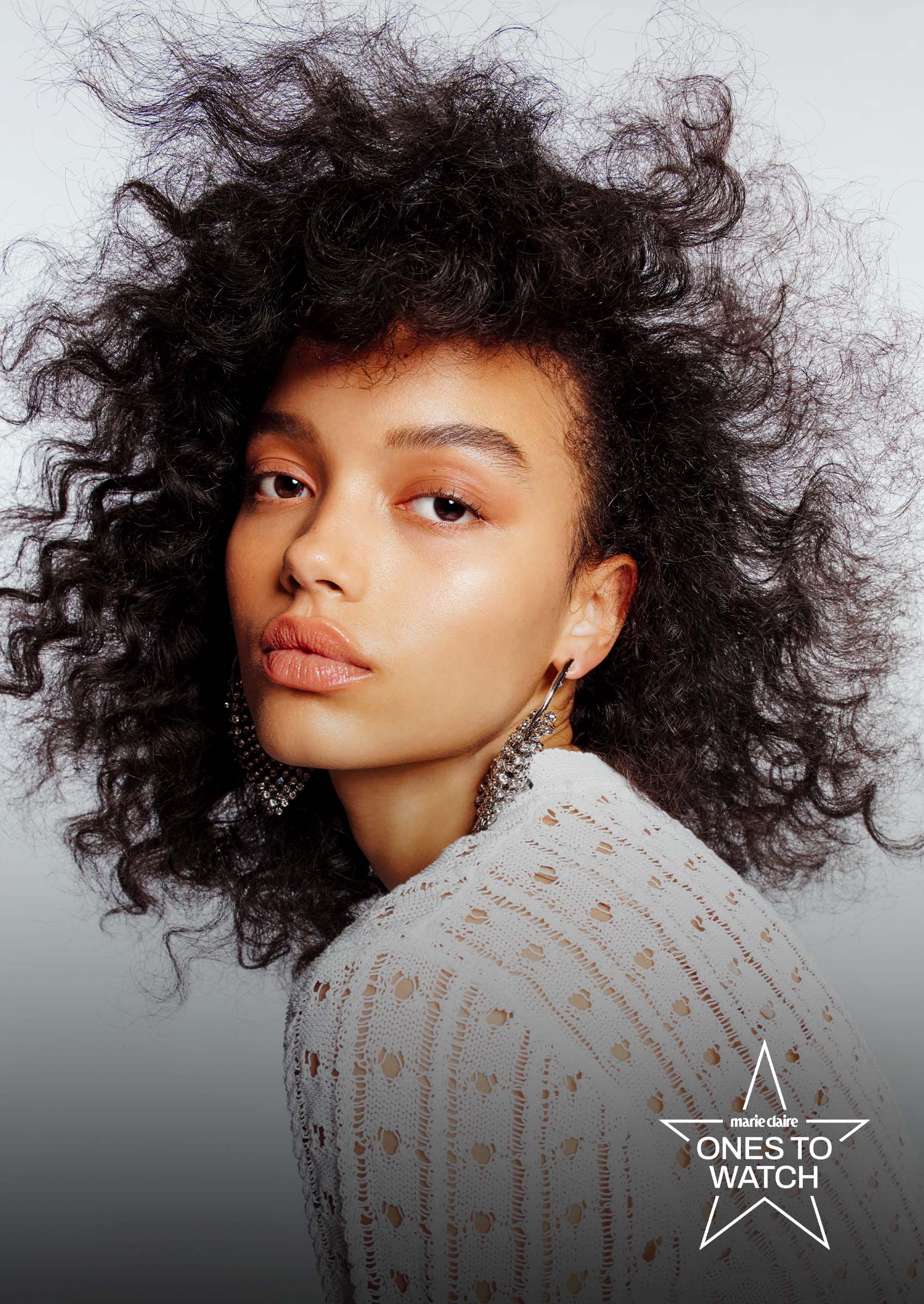 whitney peak poses in a patterned top looking over her shoulder