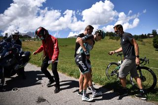 Team Bora rider Germanys Emanuel Buchmann is helped by a staff member after a crash during the fourth stage of the 72nd edition of the Criterium du Dauphine cycling race 153 km between Ugine and Megeve on August 15 2020 Photo by AnneChristine POUJOULAT AFP Photo by ANNECHRISTINE POUJOULATAFP via Getty Images
