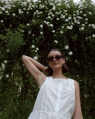 Content creator Mary L Jean in front of a rose hedge