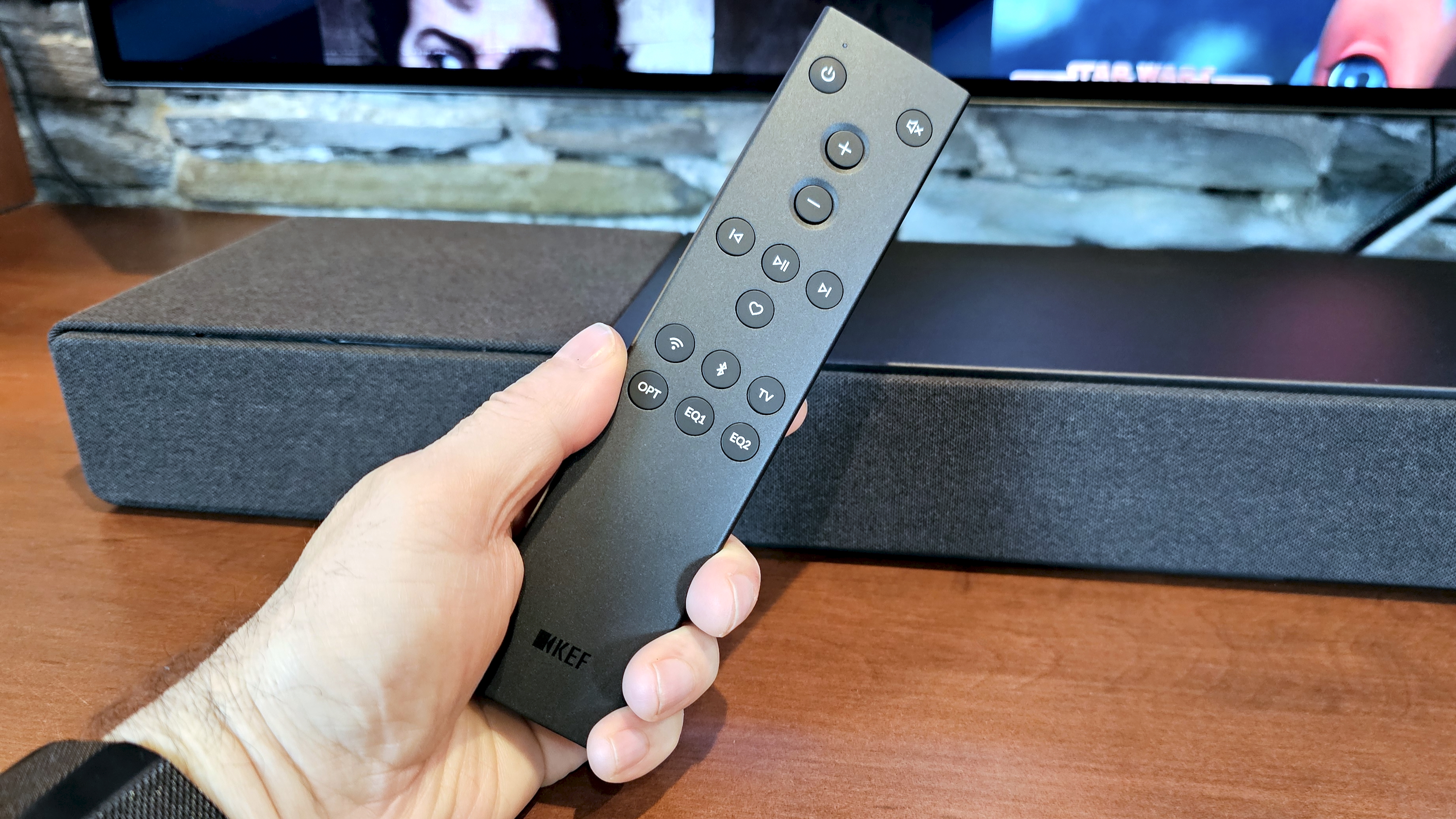 KEF XIO remote control held in hand
