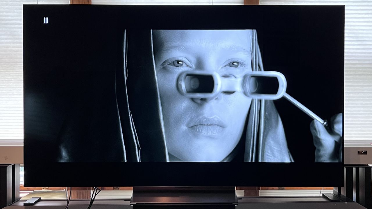 TV OLED LG C4 che mostra l'immagine di una donna che guarda attraverso gli occhiali