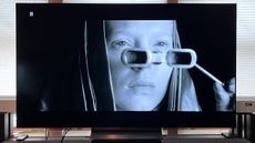 LG C4 OLED TV showing image of woman looking through glasses