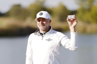 David Skinns holds up his replica PGA Tour card after qualifying through the Korn Ferry Tour Championship in 2023