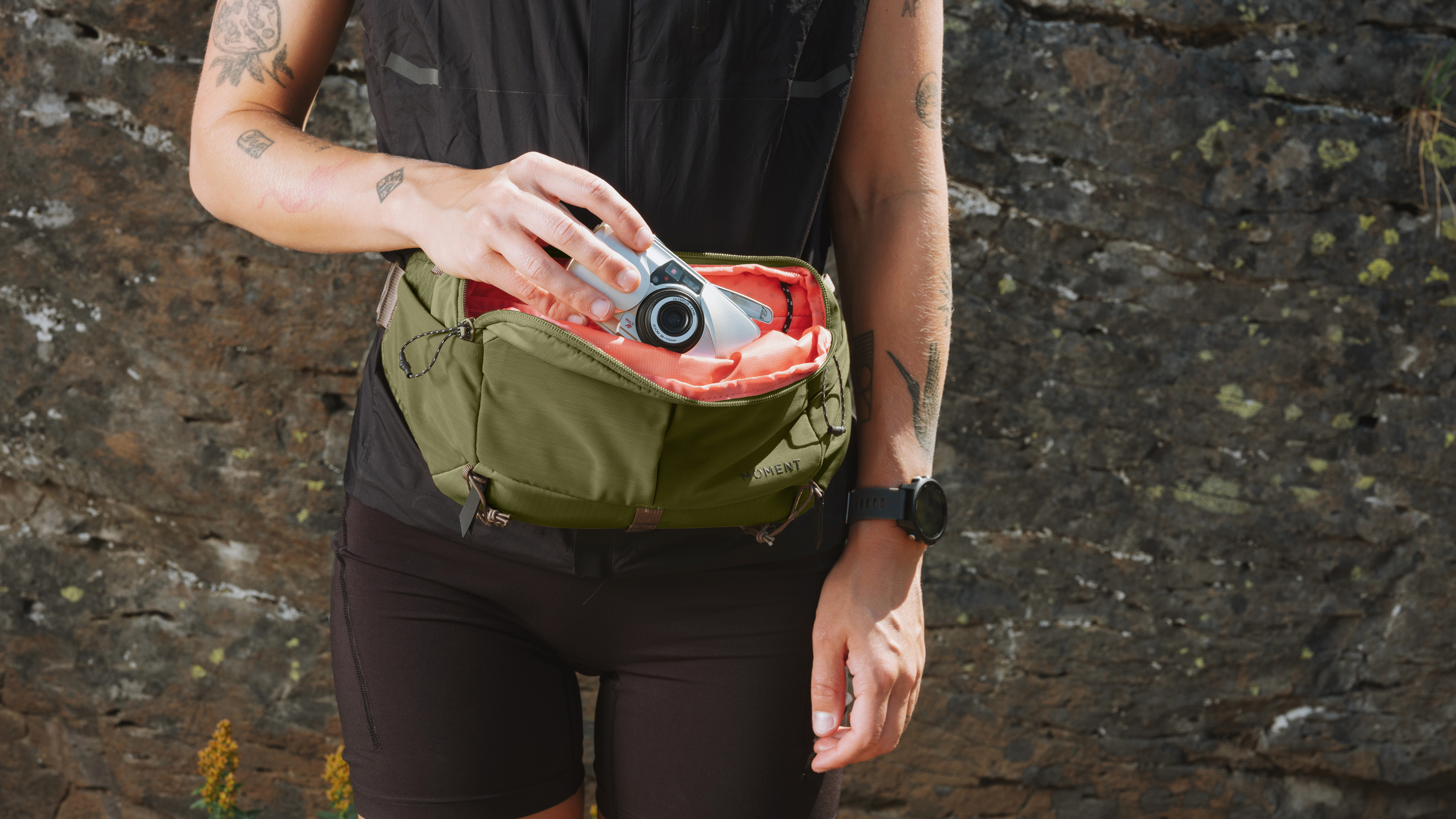 A photographer wearing the Moment Slate Sling