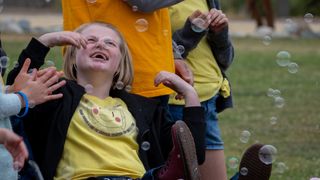 A girl with Angelman syndrome is pictured playing with bubbles in the air