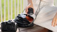 Viltrox AF 40mm f/2.5 Z lens being pulled out of a bag on a park bench
