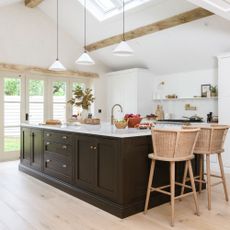 Black and white kitchen with white conical lighting above the kitchen island