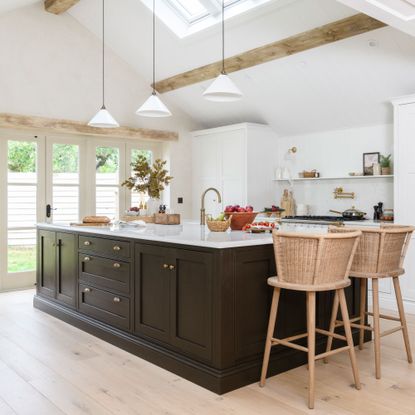 Black and white kitchen with white conical lighting above the kitchen island
