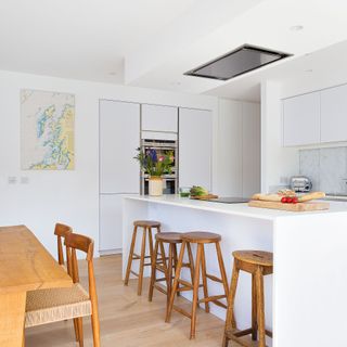 White kitchen with hidden extractor fan over the kitchen island induction hob