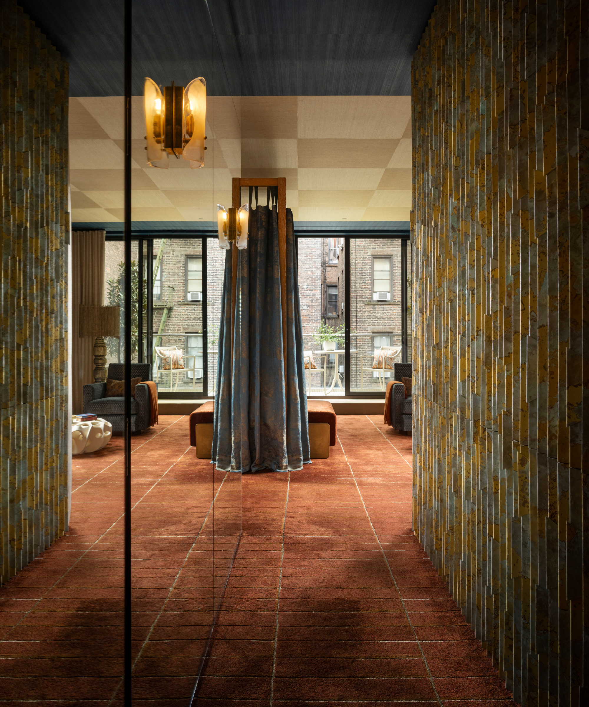 Contemporary NYC bedroom entryway anchored by a terracotta silk-and-wool carpet with subtle geometry