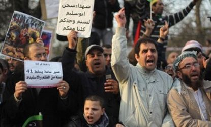 Qaddafi could be forced out of Libya in a matter of days, says on international analyst. Anti-government protesters rally outside the Libyan embassy in London