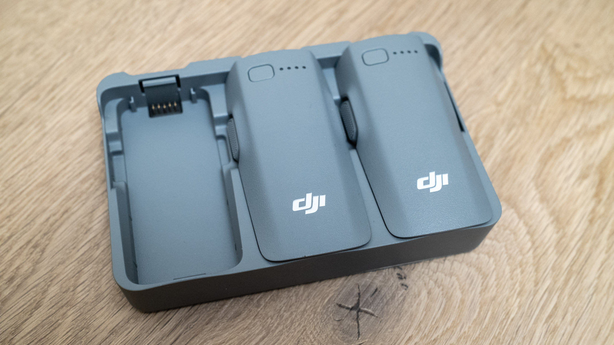DJI Neo 2 battery charging hub on a wooden floor