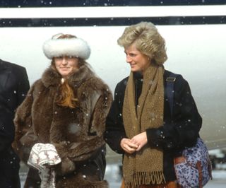 ZURICH, SWITZERLAND - MARCH 08: Diana, Princess of Wales (L), wearing a brown suede skirt and black boots, and Sarah, Duchess of York arrive in the snow at Zurich Airport for a skiing holiday on March 8, 1988 in Zurich, Switzerland. (Photo by Anwar Hussein/Getty Images)