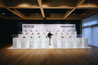 Adidas Football VP of Design Sam Handy stands in front of the Adidas Predator football boot archive / timeline