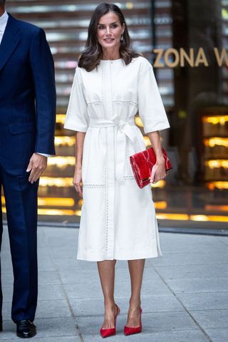 Queen Letizia wearing a white midi dress and red accessories