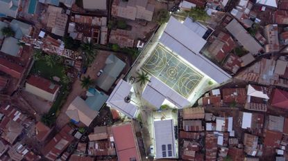 aerial view of town, brightly lit Uganda community centre in middle