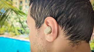 Campfire Audio Orbit earbuds worn by reviewer outside by a swimming pool