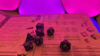 A set of D&D dice on a Dungeon Master's screen with Nanoleaf Shapes in the background