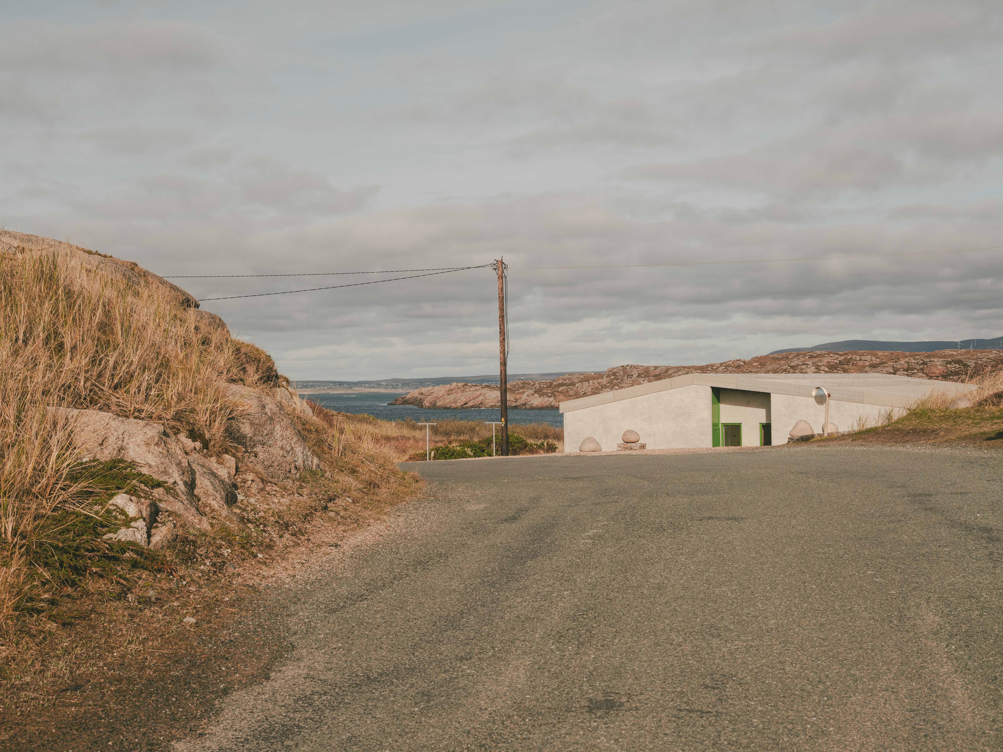 The house sits below a crest on a quiet road on Cruit Island on the Atlantic coast