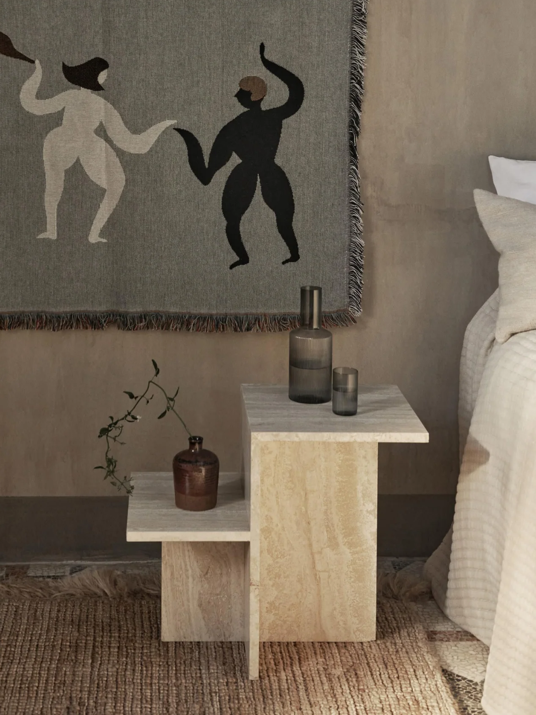 A beige travertine side table with varied tops from Ferm Living