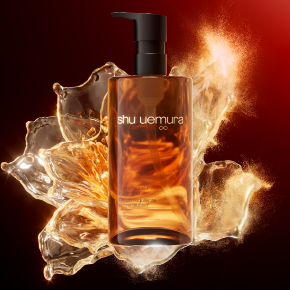 An amber glass bottle from Shu Uemura in front of an amber tinted water splash. 