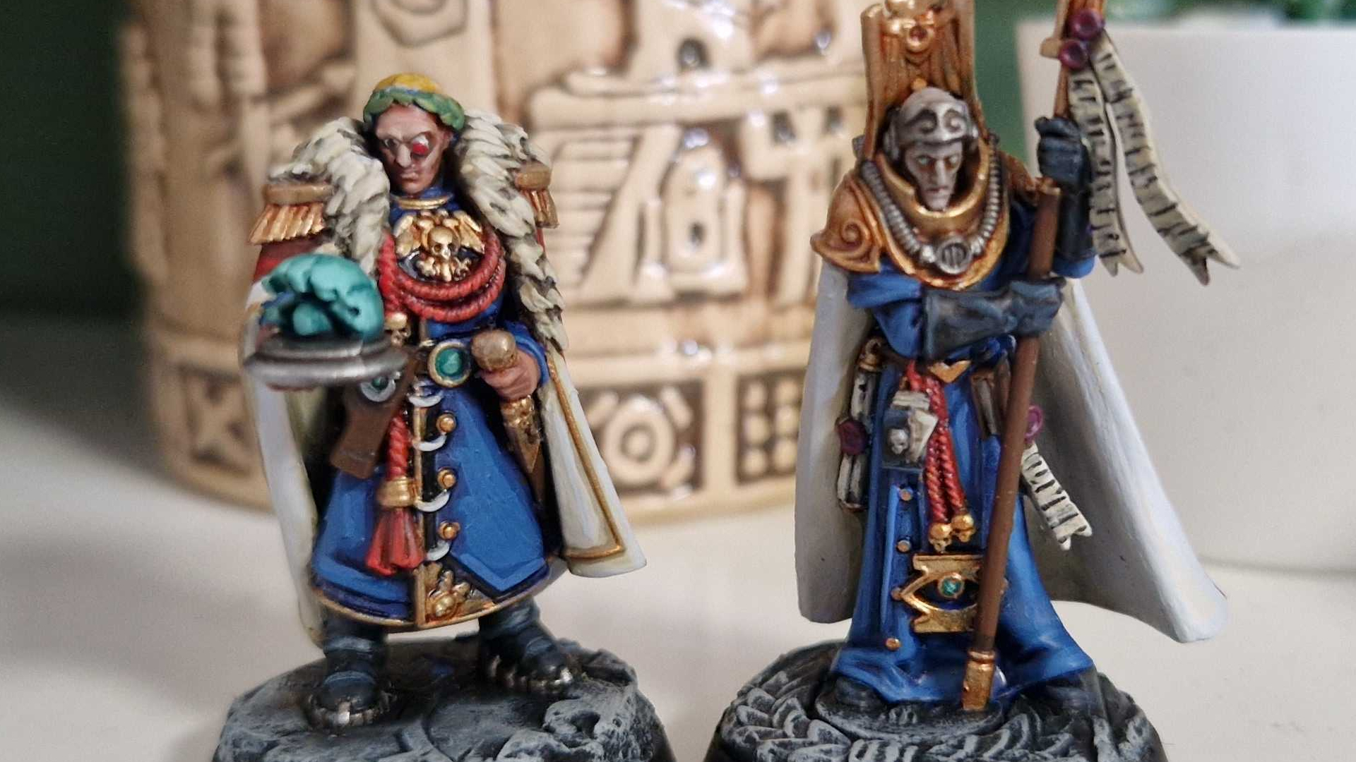 Two Imperial models from the Wardens of Ultramar box set in front of a tiki cup and white plant pot