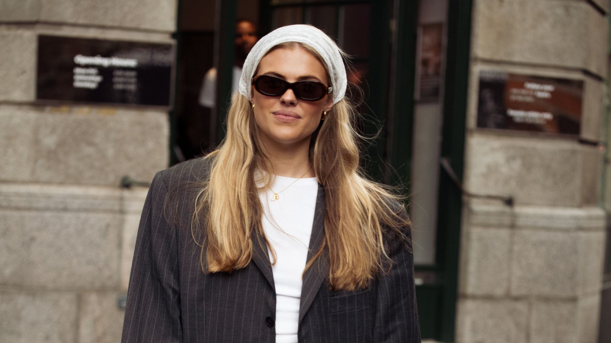 street style shot of blonde woman wearing bandana and sunglasses