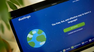 A laptop displaying Duolingo's sign-up screen.