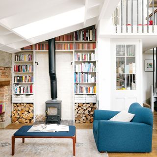blue armchair in living space with fireplace and bookshelves
