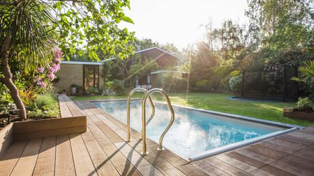 A bckyard swimming pool with decked area