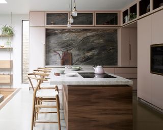 Pink kitchen with wood island and chairs