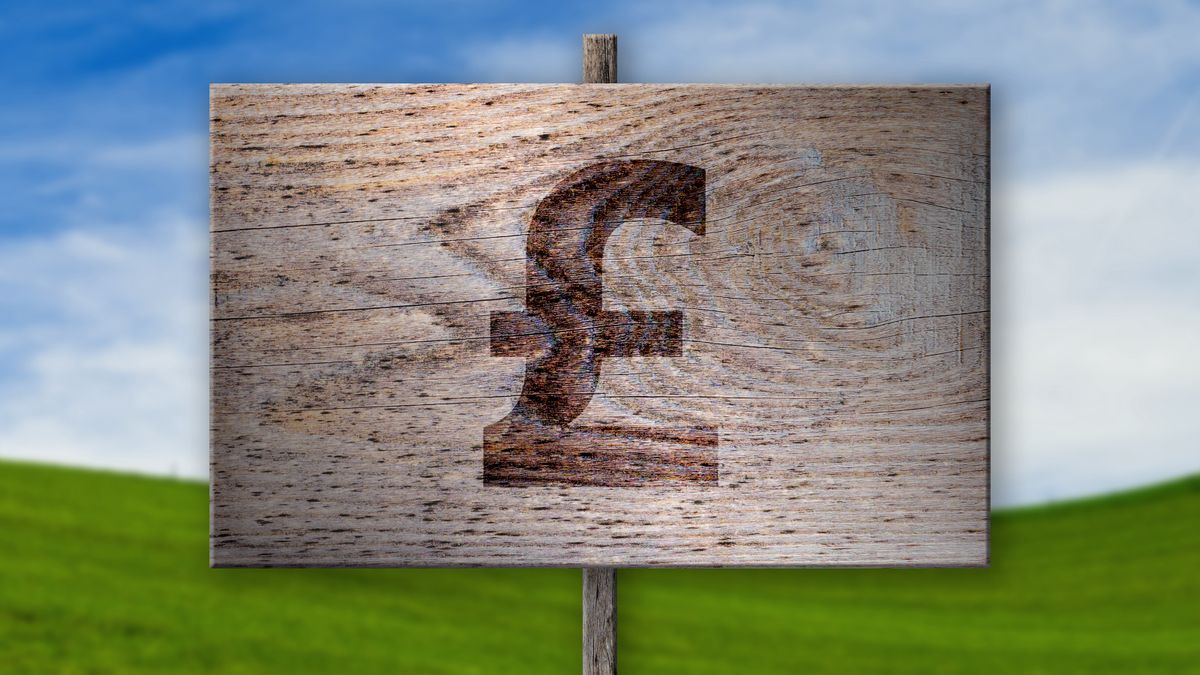 Wooden sign with pound sign on it with area of green grass and sky behind