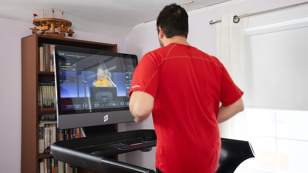 man running on Peloton Tread Plus with closeup of display