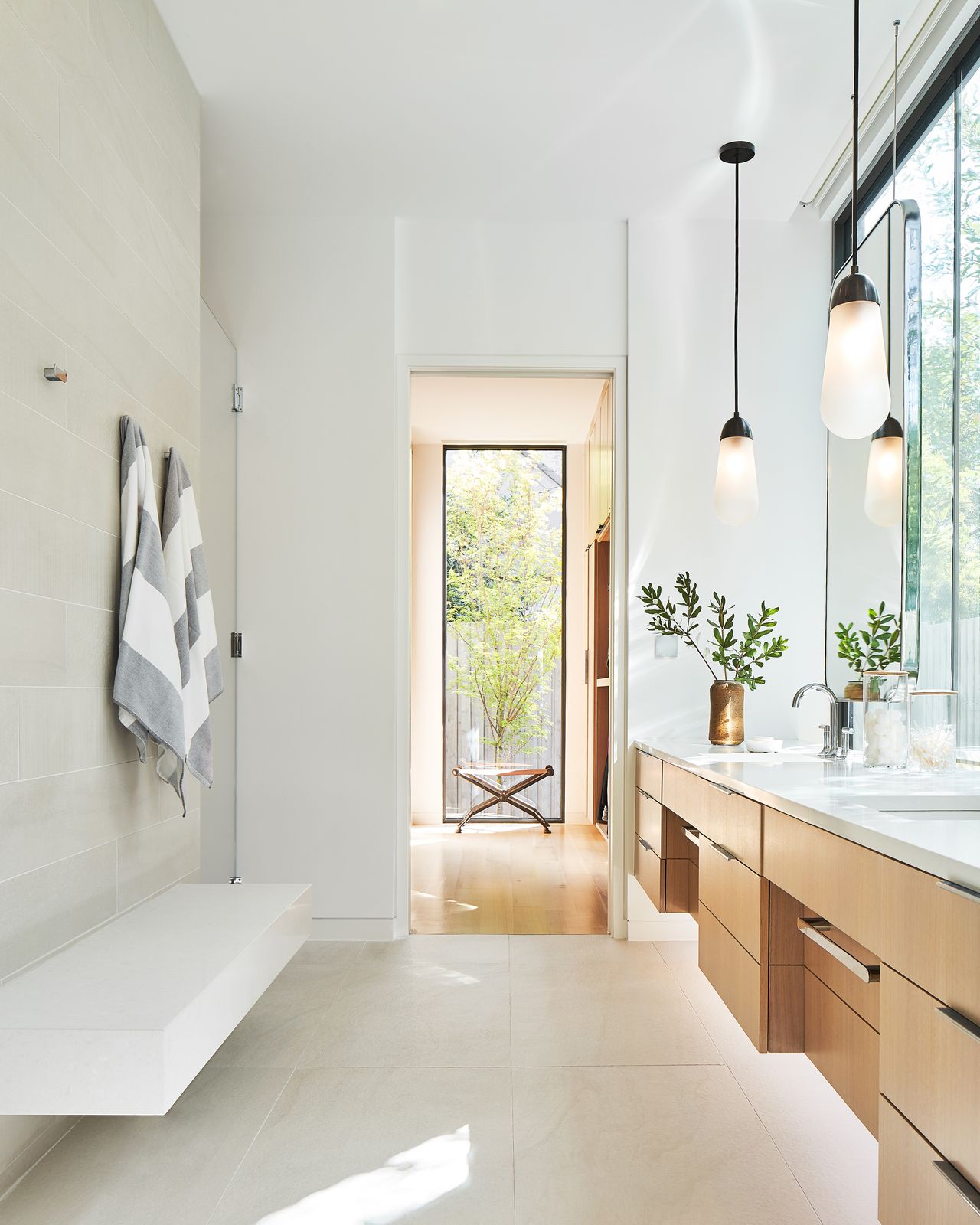 White bathroom, stone tile wall and marble bench and countertop