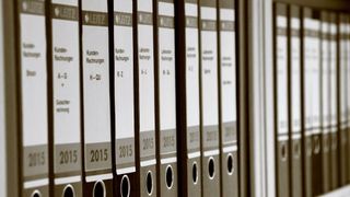 A shelf filled with folder files.