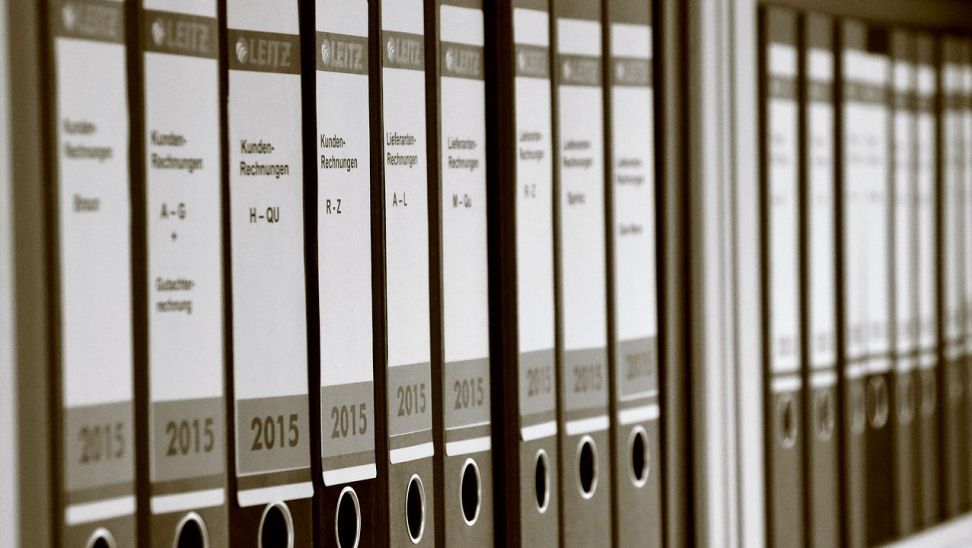 A shelf filled with folder files 