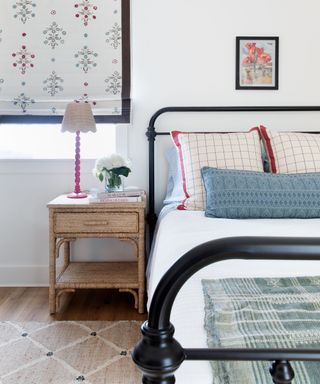 red white and blue cozy bedroom with vintage bed and woven rug