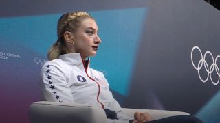 Amber Glenn nervously sits in the leader's chair at the Olympics.