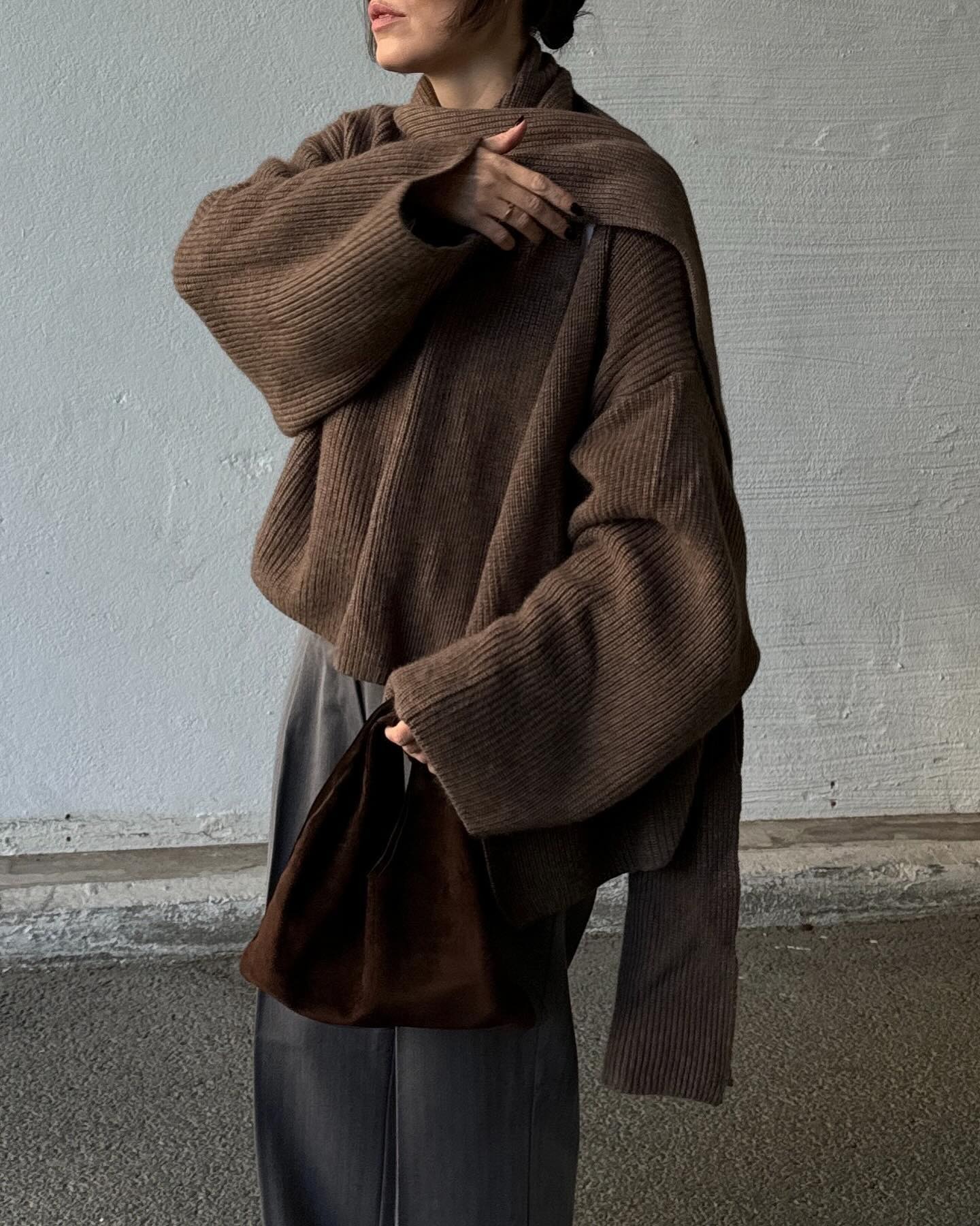 Annabel Rosendahl wears a brown scarf sweater with brown trousers.